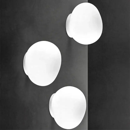 Three minimalist white glass egg wall sconces with a smooth matte finish modern wall lamp for bedroom lighting