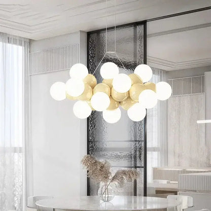 Modern white glass globe pendant light fixture with glossy white and gold spherical bulbs on a minimalist metal frame