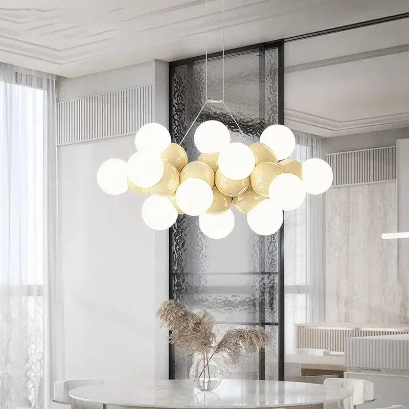 Modern white glass globe pendant light fixture with glossy white and gold spherical bulbs on a minimalist frame for dining room