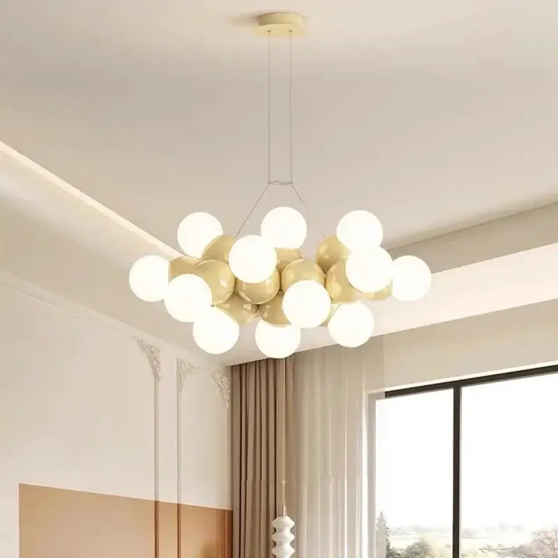 Modern white glass globe pendant light fixture with glossy white and gold bulbs suspended from minimalist mount