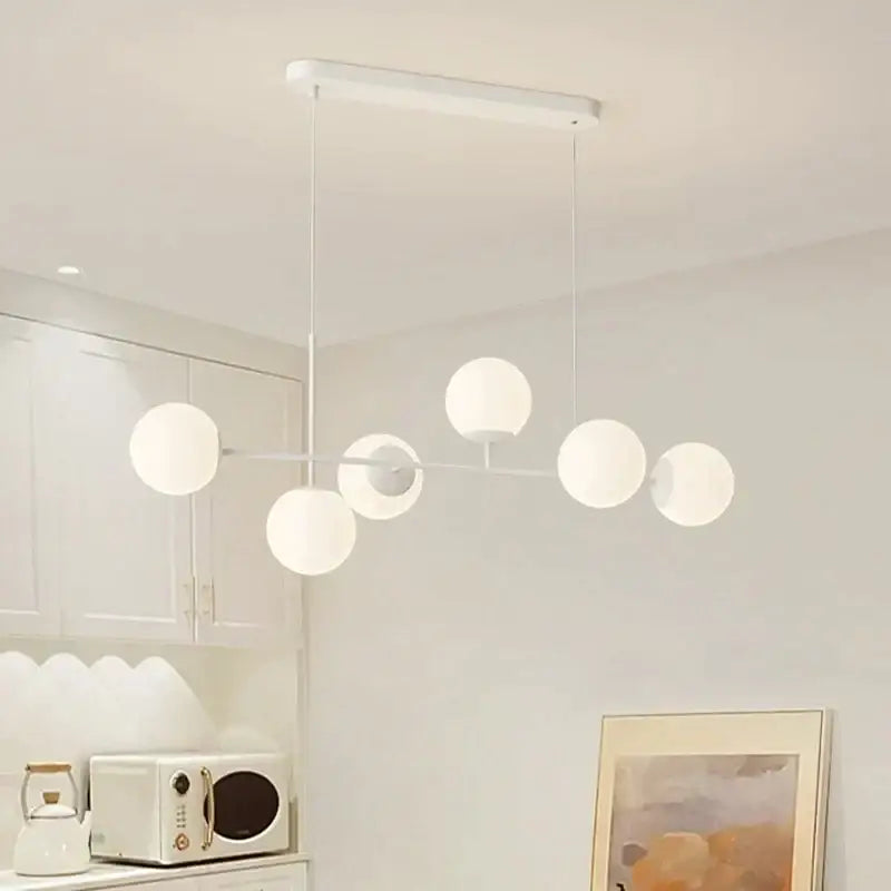 Modern white glass pendant chandelier light set featuring spherical glass globes and minimalist metal frame for dining room