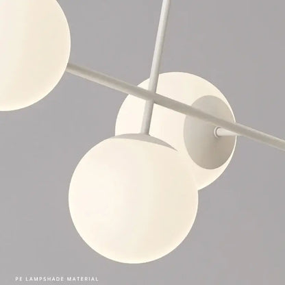 Modern white glass pendant chandelier light set with spherical lampshades suspended from minimalist metal frame