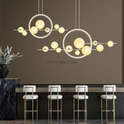 Modern white glass strip bubble chandelier with warm yellow globe bulbs suspended above kitchen bar decorbites glass strip