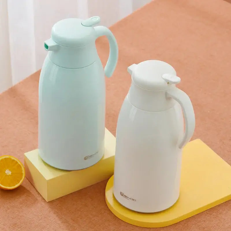 Two pastel mint green and white decorbites glass insulation kettles with curved handles and lids for kitchen use