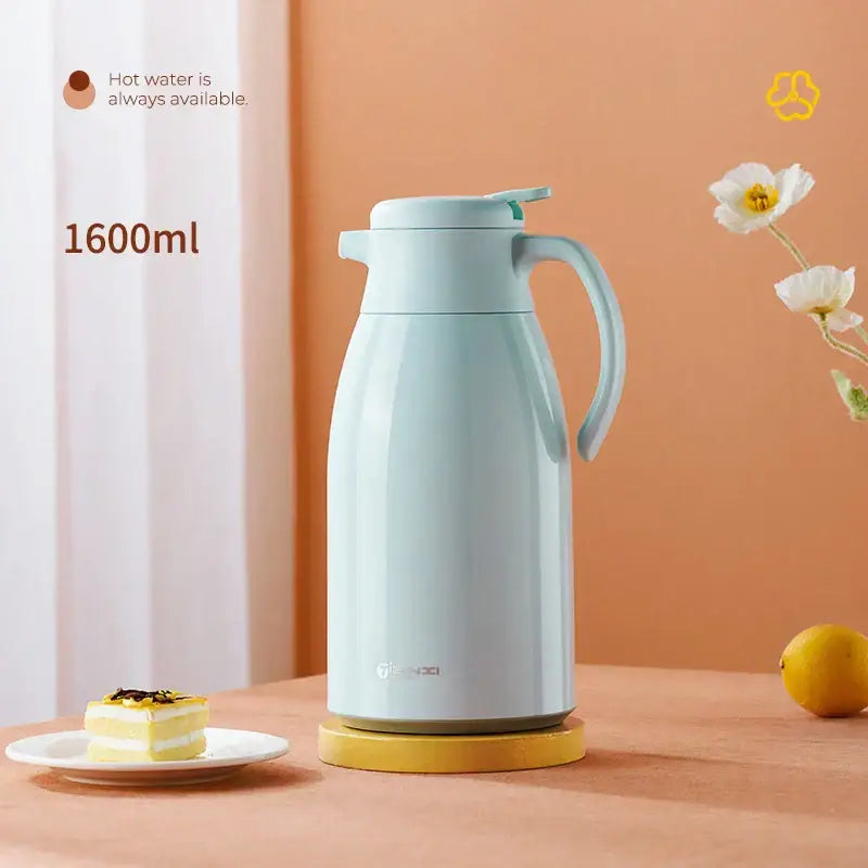 A sleek light blue decorbites glass insulation kettle with a matching lid and handle on a yellow base