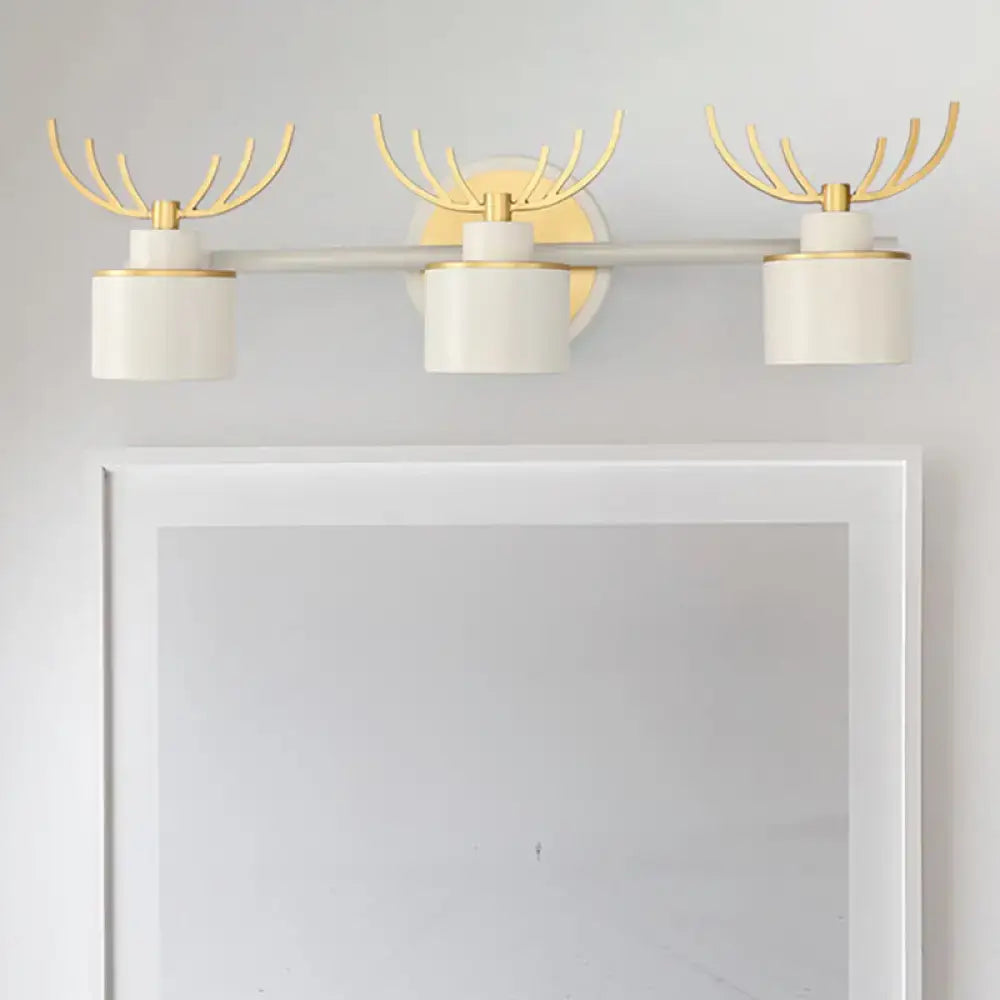 Modern white and gold antler wall light fixture with three cylindrical lights mounted on a horizontal bar for bathroom vanity