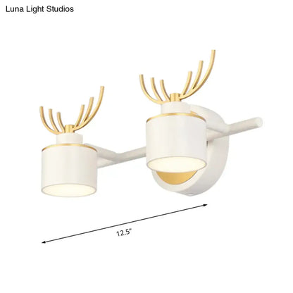 Modern white and gold deer-themed wall light fixture with two cylindrical LED shades for bathroom vanity use