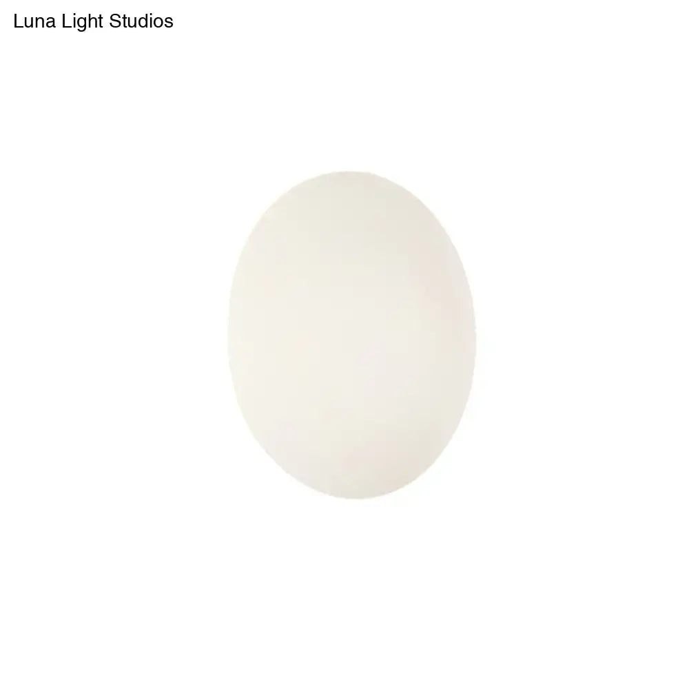 A smooth oval-shaped white egg resembling the modern white gold circular warm white wall light for bedroom use