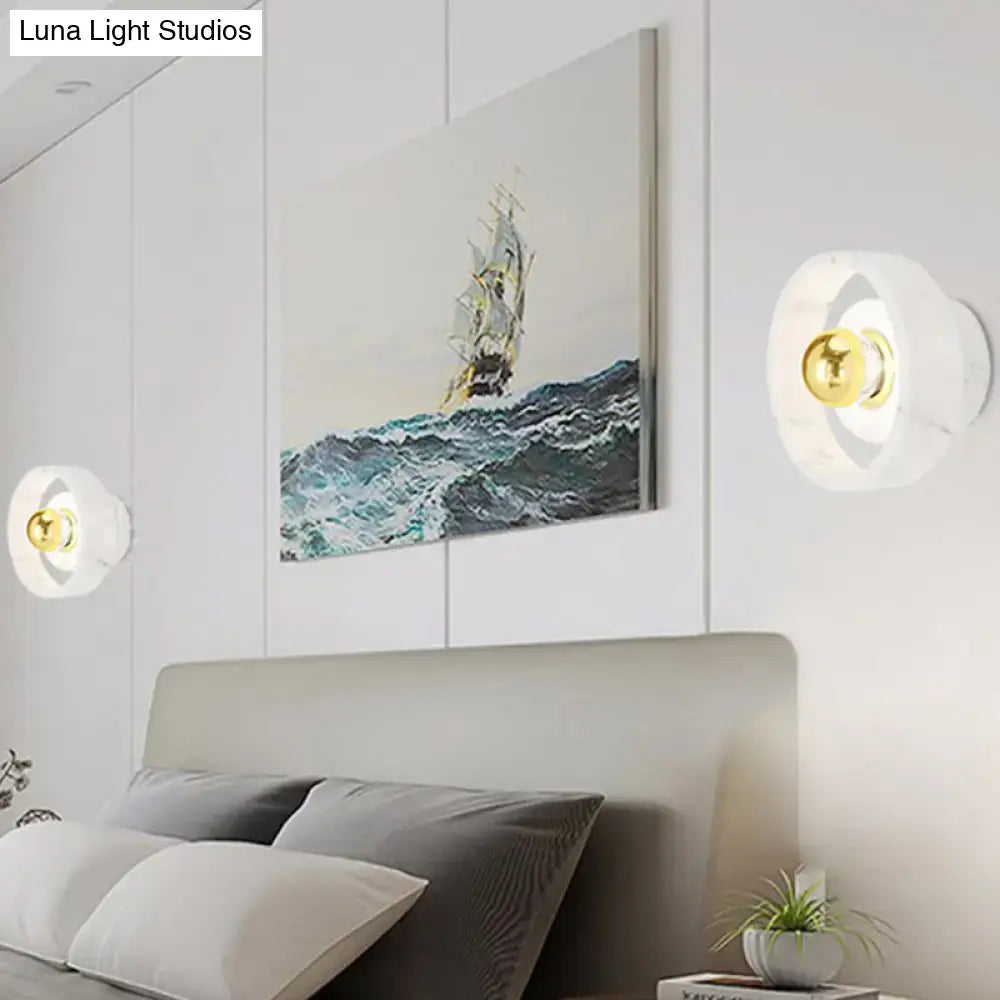 Modern white marble-finish designer wall sconce with polished gold spherical bulb for bedroom LED lighting