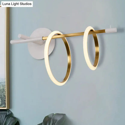 Modern white and gold ring light fixture wall light with two illuminated gold-rimmed rings on brass rod, modernist wall light