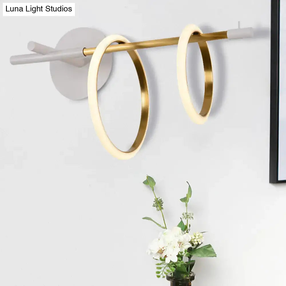 Modern white and gold ring light fixture wall light with two illuminated gold-toned circular rings minimalist design