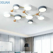 Modern white and gray wood ceiling chandelier with circular bulbs connected by gold metal arms for living room lighting
