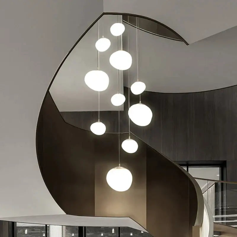 Modern white gregg glass suspension pendant light with multiple spherical bulbs on a sleek curved metal frame for villa staircase decorbites gregg glass pendant light