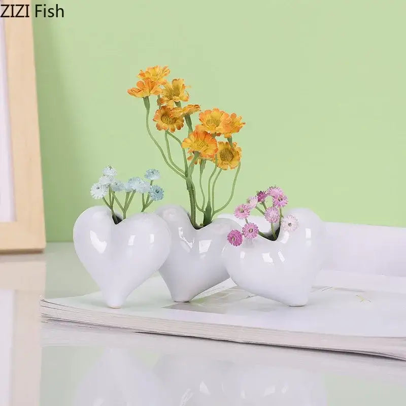 Set of three modern white glossy decorbites heart ceramic vases with artificial greenery for desk decor