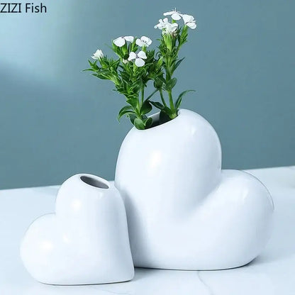 Modern white decorbites heart ceramic vases with glossy finish holding delicate white flowers for desk decor
