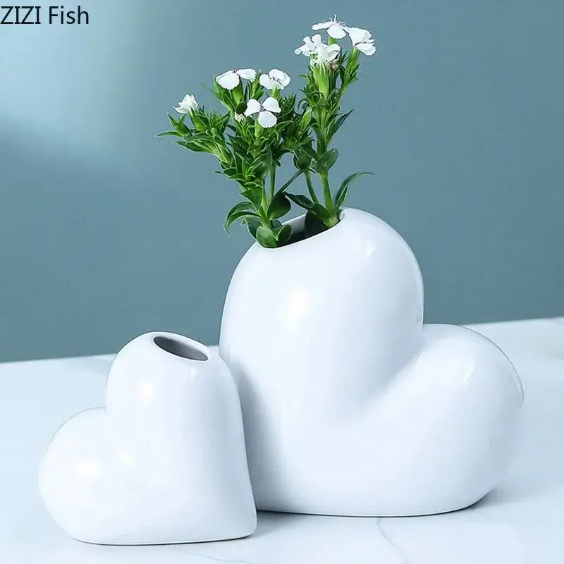 Modern white decorbites heart ceramic vases with glossy finish holding delicate white flowers for desk decor