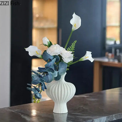 Modern white decorbites heart ceramic vase with vertical ridged texture holding white calla lilies and blue orchids