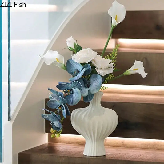 Modern white decorbites heart ceramic vase with vertical ridged texture holding blue orchids and white calla lilies