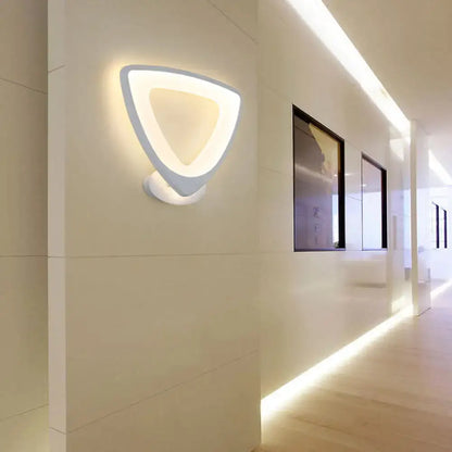 Modern white triangular led wall sconce with a sleek minimalist design for bedroom lighting