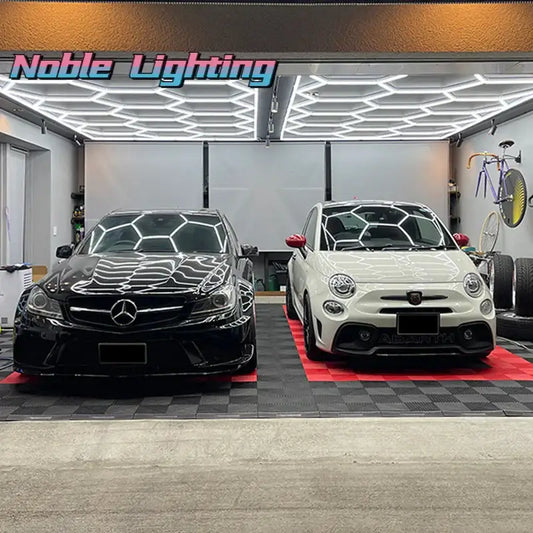 Black and white Mercedes-Benz C-Class sedan parked beside white Fiat 500 under decorbites hexagon ceiling light