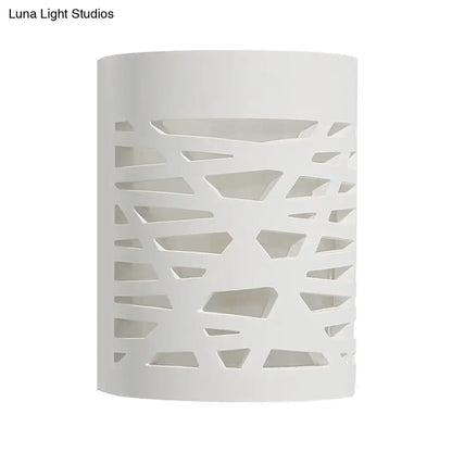 Modern white cylindrical wall sconce with geometric cutout pattern designed for bedroom led light bulb use