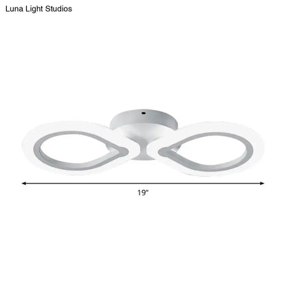 Modern white led wall light fixture with two infinity-looped rings featuring a simple design and adjustable fixture height