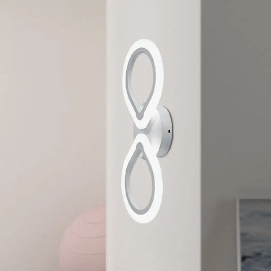 Modern white led wall sconce with two interlocking ring light fixtures featuring a simple design and optimal fixture height