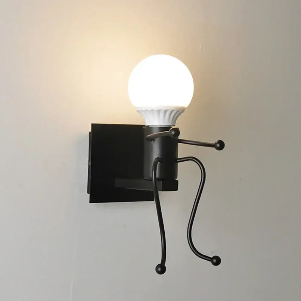 Black metal wall sconce with whimsical iron man cartoon stick-figure design and illuminated white bulb for bedroom use