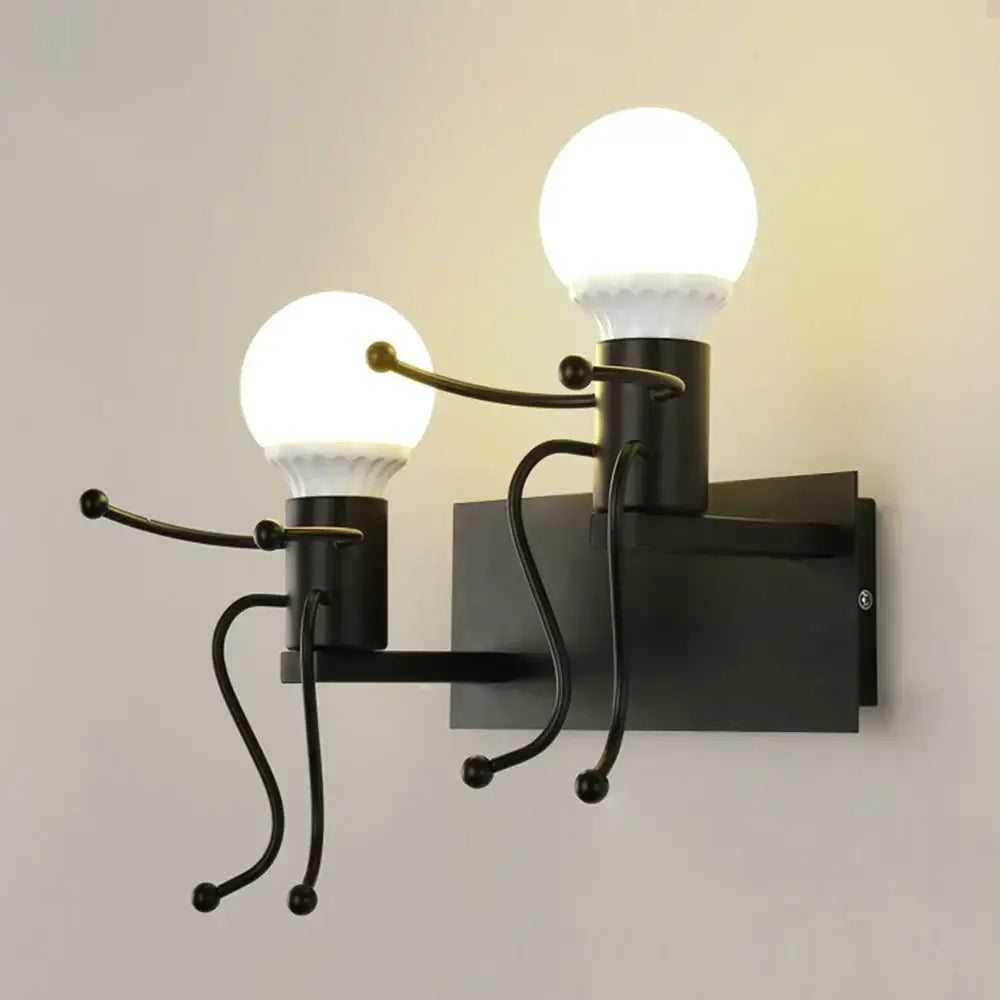 Modern white iron man cartoon wall sconce with black metal stick-figure arms holding spherical light bulbs for bedroom
