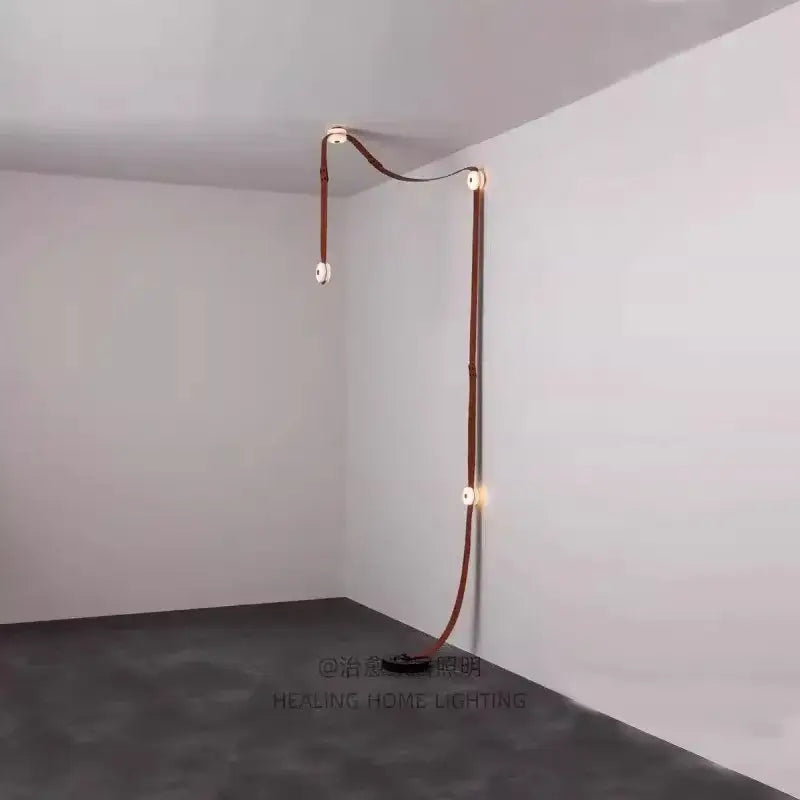 A sleek copper-toned leather-wrapped led wall sconce with minimalist design for decorbites designer belt marble pendant lights