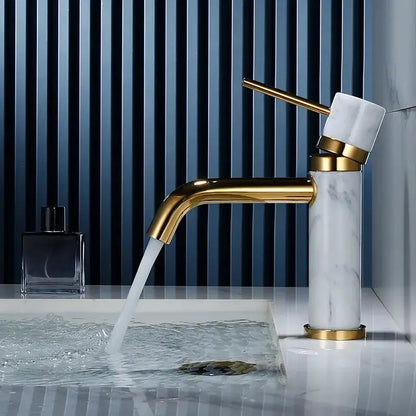 A modern white marble bathroom faucet with brushed gold finish and elegant curved swivel spout by decorbites
