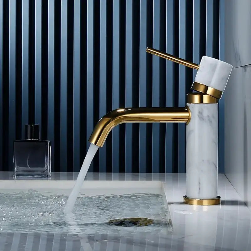 A modern white marble bathroom faucet with brushed gold finish and elegant curved swivel spout by decorbites