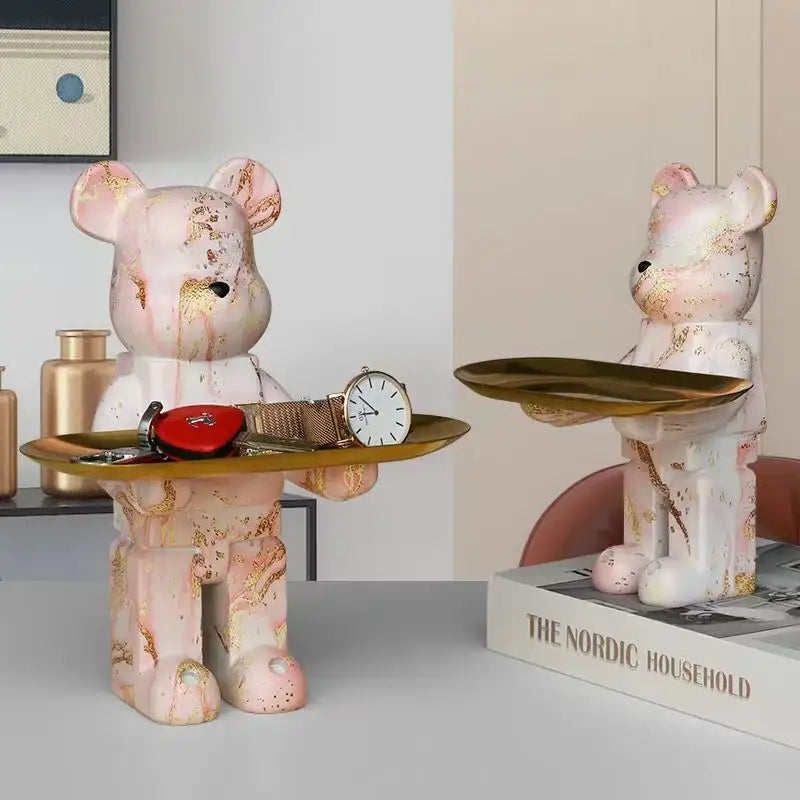 Pink marble-finish bear figurine sculpture with gold leaf accents holding a golden tray for living room decor