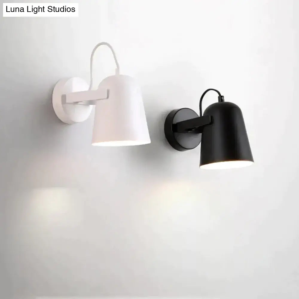 Modern white matte adjustable ferrell wall lamp with cylindrical shades and sleek black and white finishes for bedroom use