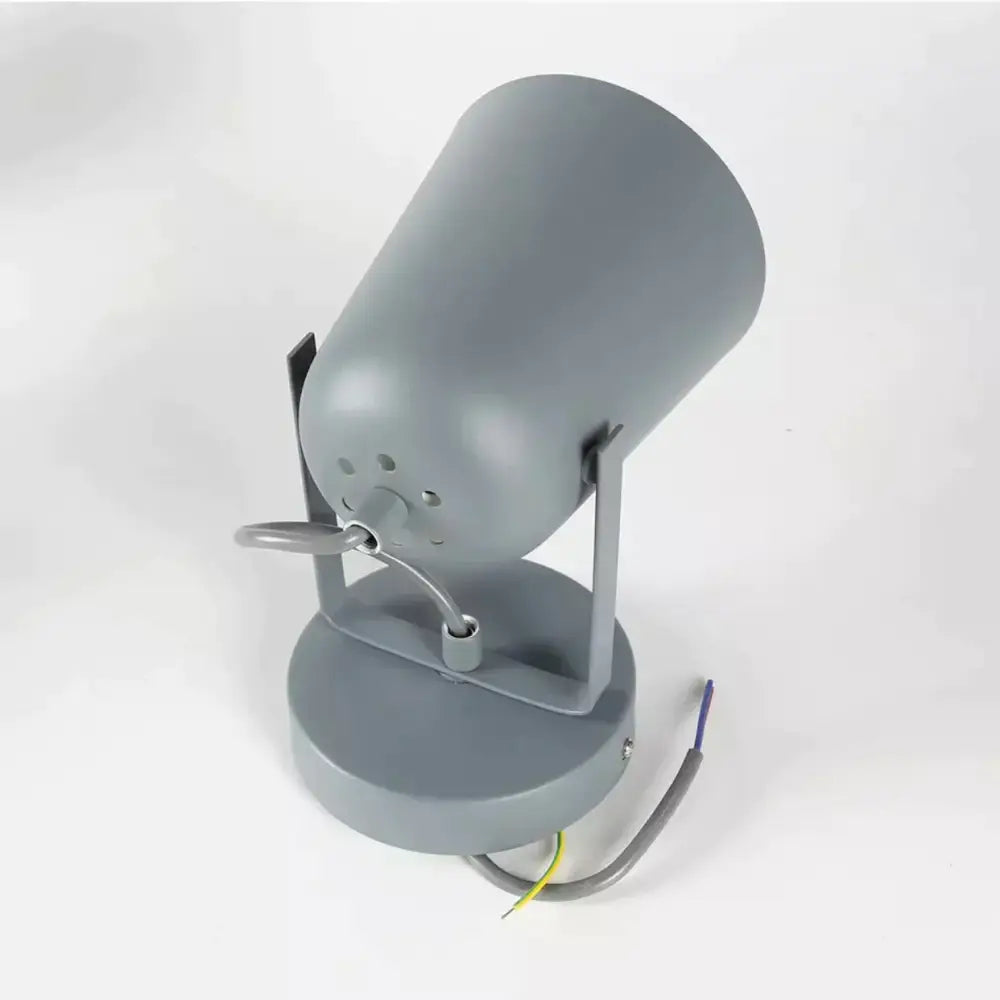 Gray cylindrical spotlight with matte finish and adjustable arm mounted on circular base for modern ferrell wall lamp use