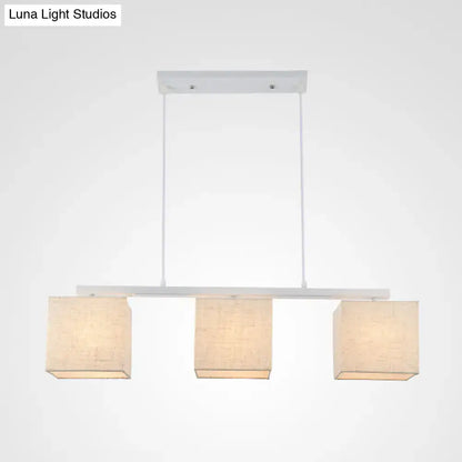 DecorBites modern white island light fixture with three square beige fabric shades for kitchen island lighting