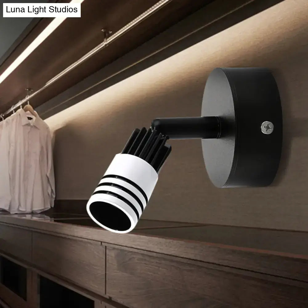 Modern white metal wall mounted led spotlight with a black and white cylindrical head featuring three stripes for reading light