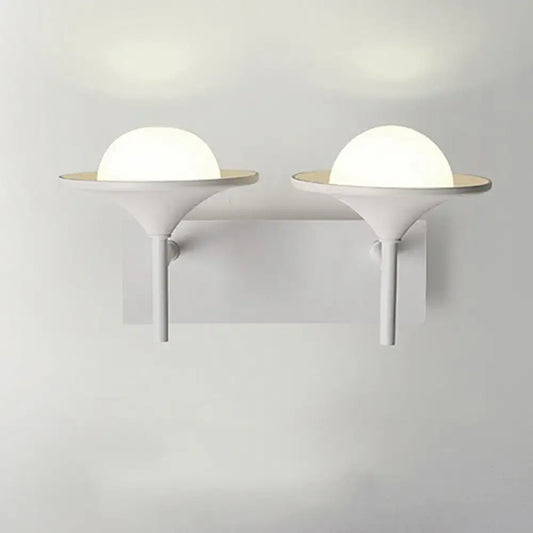 Modern white metallic flared wall sconce with frosted glass dome and sleek base for bedroom LED lighting