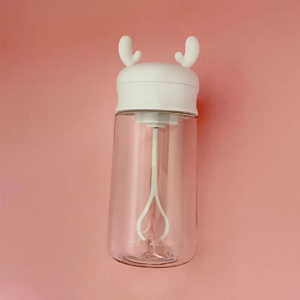 Clear plastic electric protein shaker bottle with white lid and reindeer antlers featuring internal mixing whisk