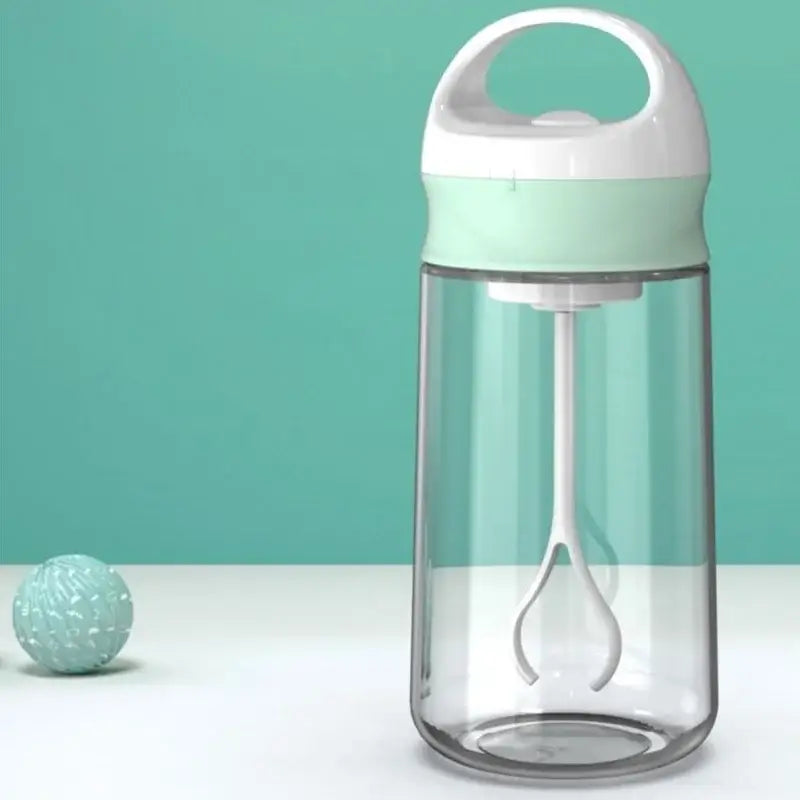 Modern white and pink electric protein shaker bottle with clear plastic body, mint green lid, and internal mixing whisk