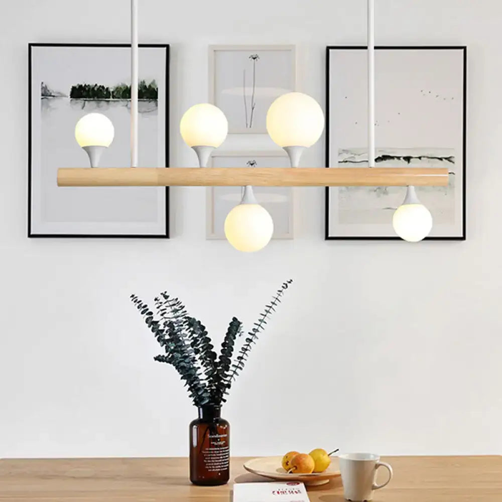 Modern white pipe island pipe island light with natural wood bar and five warm white globes for dining room use