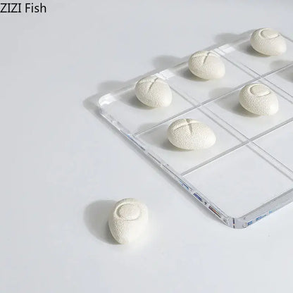 Modern white resin pieces acrylic tic-tac-toe set featuring white textured bread-shaped resin pieces on a clear tray decorbites acrylic chessboard set