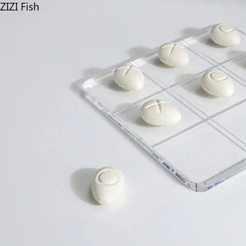 Modern white resin pieces acrylic tic-tac-toe set featuring white textured bread-shaped resin pieces on a clear tray decorbites acrylic chessboard set