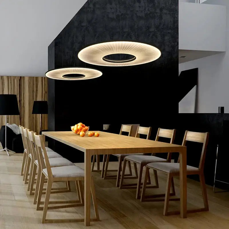 Modern white ribbed circular pendant lights with warm glow and concentric rings hang above dining table decorbites hanging ceiling lamps