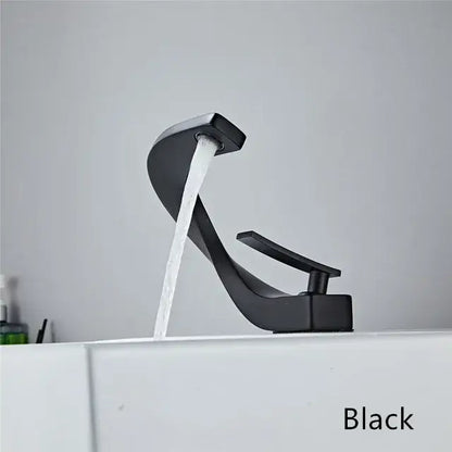 Black matte basin faucet with sleek curved design and waterfall spout for modern white and rose gold bathroom decor