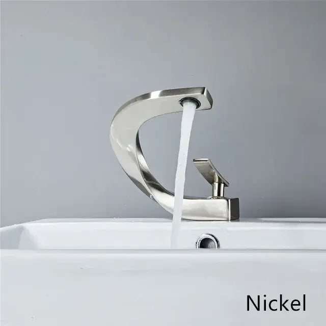 Modern basin faucet with nickel finish, sleek curved spout, and rectangular handle for elegant rose gold bathroom setup