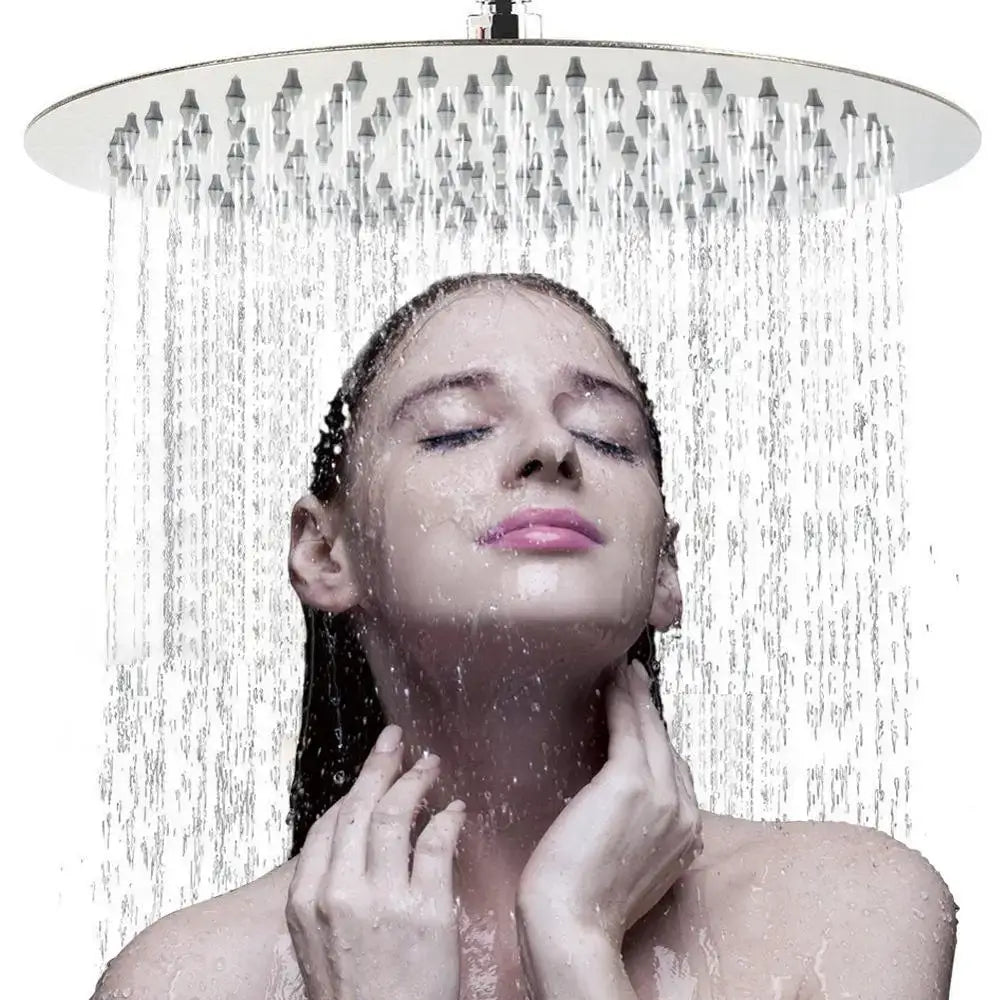 A sleek white round rainfall shower head with chrome finish and multiple jets emitting a steady water stream