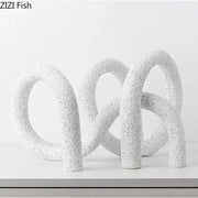 Modern white speckled resin abstract twisted knot sculpture with interlocking looped forms for living room decor