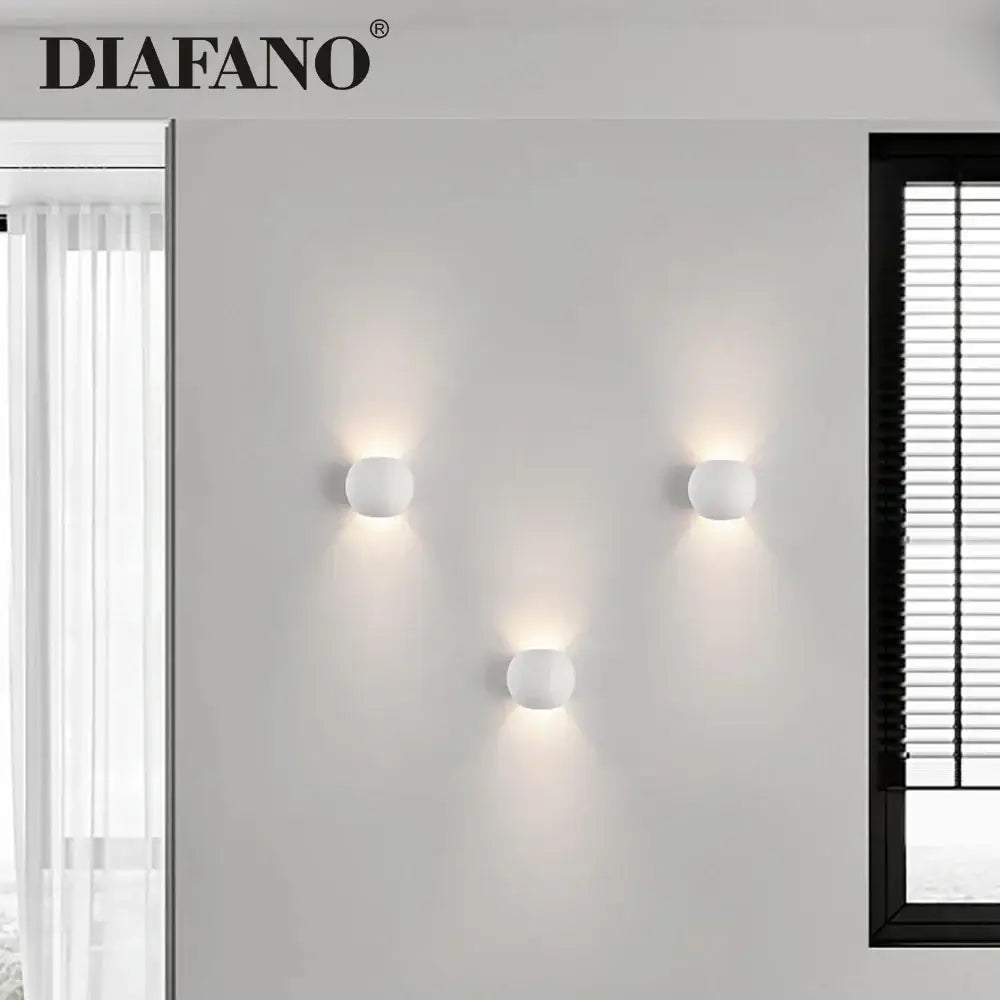 Three minimalist white spherical gypsum led wall lamps by diafano ideal as modern bedroom wall sconces