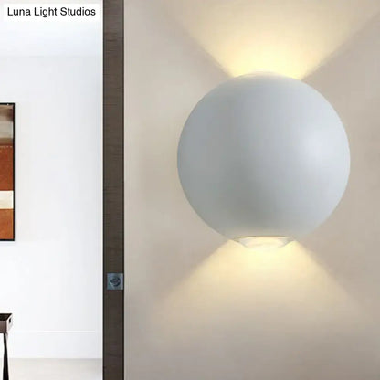 A sleek matte white spherical wall light fixture with minimalist design for modern outdoor wall lighting
